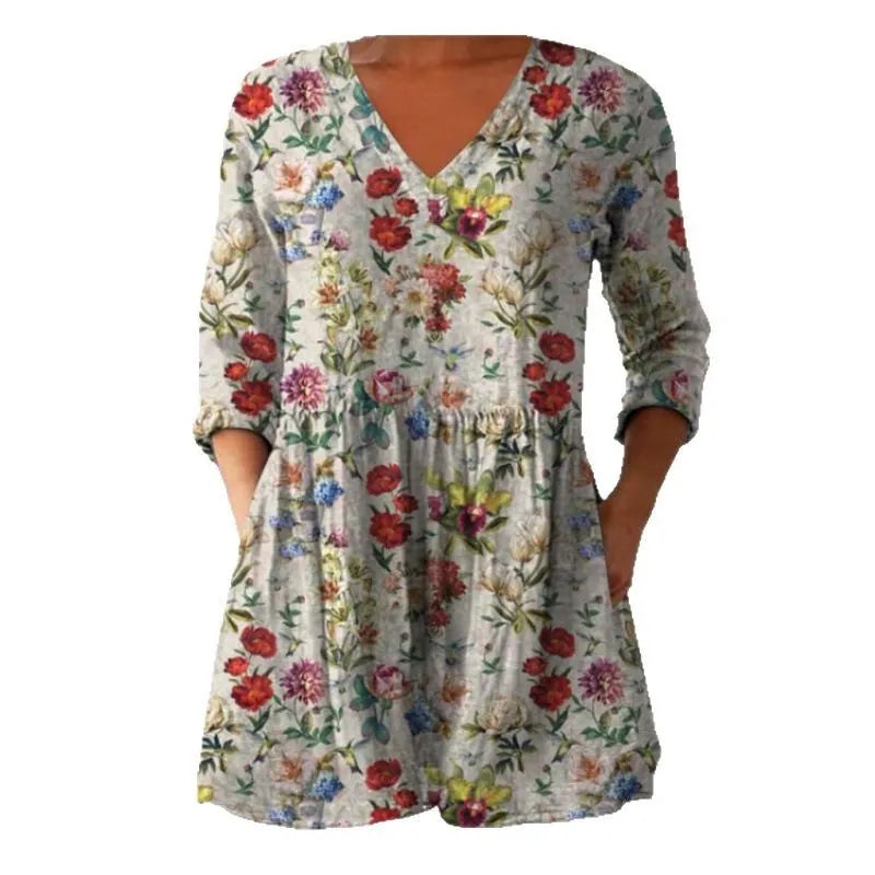A woman wearing a printed, loose-fitting dress with a wide waist and three-quarter length sleeves.