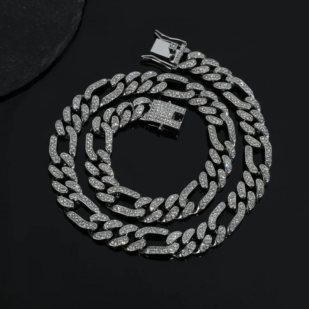 Rap style figaro chain necklace with geometric rhinestone pendant in silver colour on a plain background