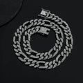 Rap style figaro chain necklace with geometric rhinestone pendant in silver colour on a plain background
