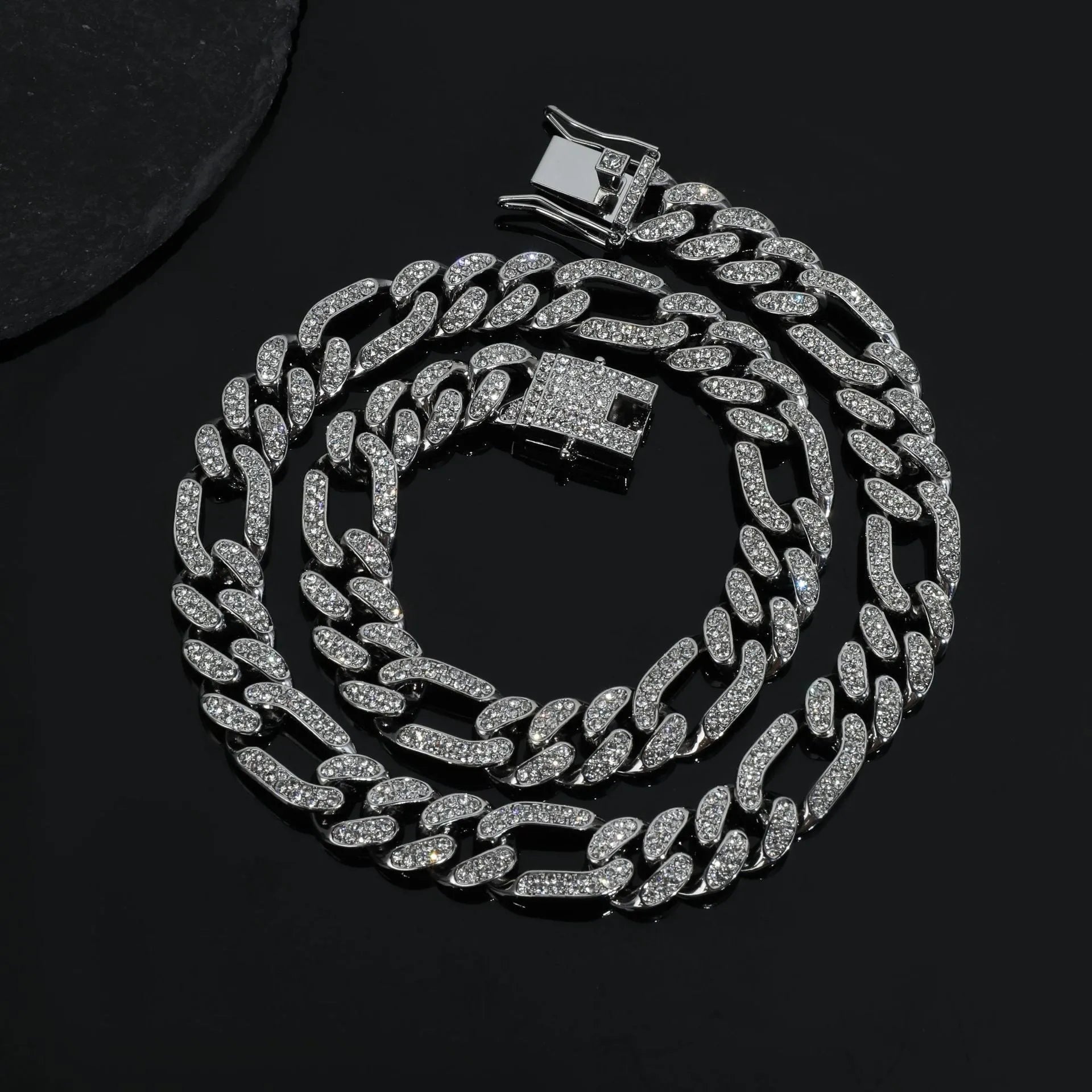 Rap style figaro chain necklace with geometric rhinestone pendant in silver colour on a plain background