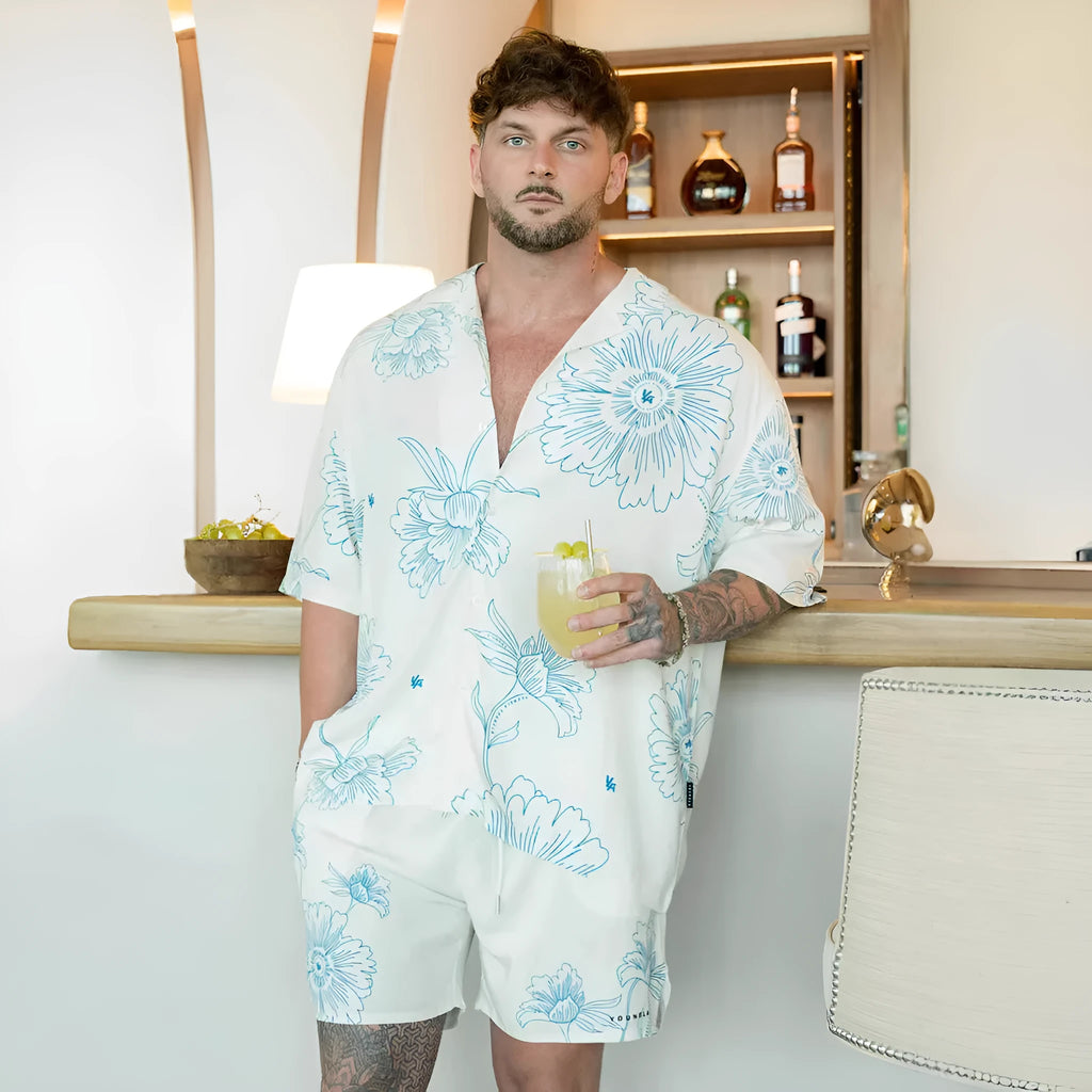 Man wearing a loose, short-sleeved printed floral top in a light colour.
