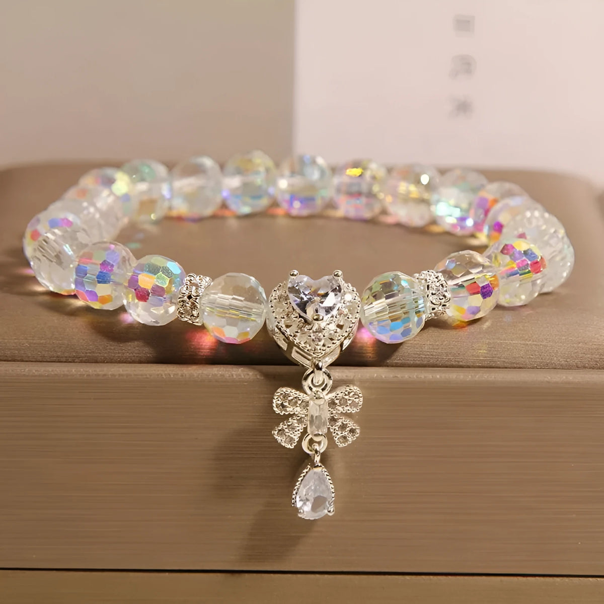 White crystal women's bracelet with butterfly and water drop charms on a metal chain, Japanese Korean style snowflake element.