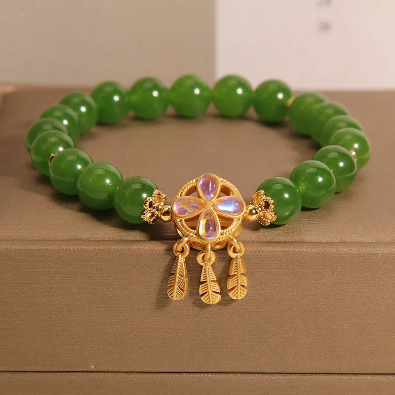 Green jasper crystal four-leaf clover dream catcher pendant on an adjustable women's bracelet.
