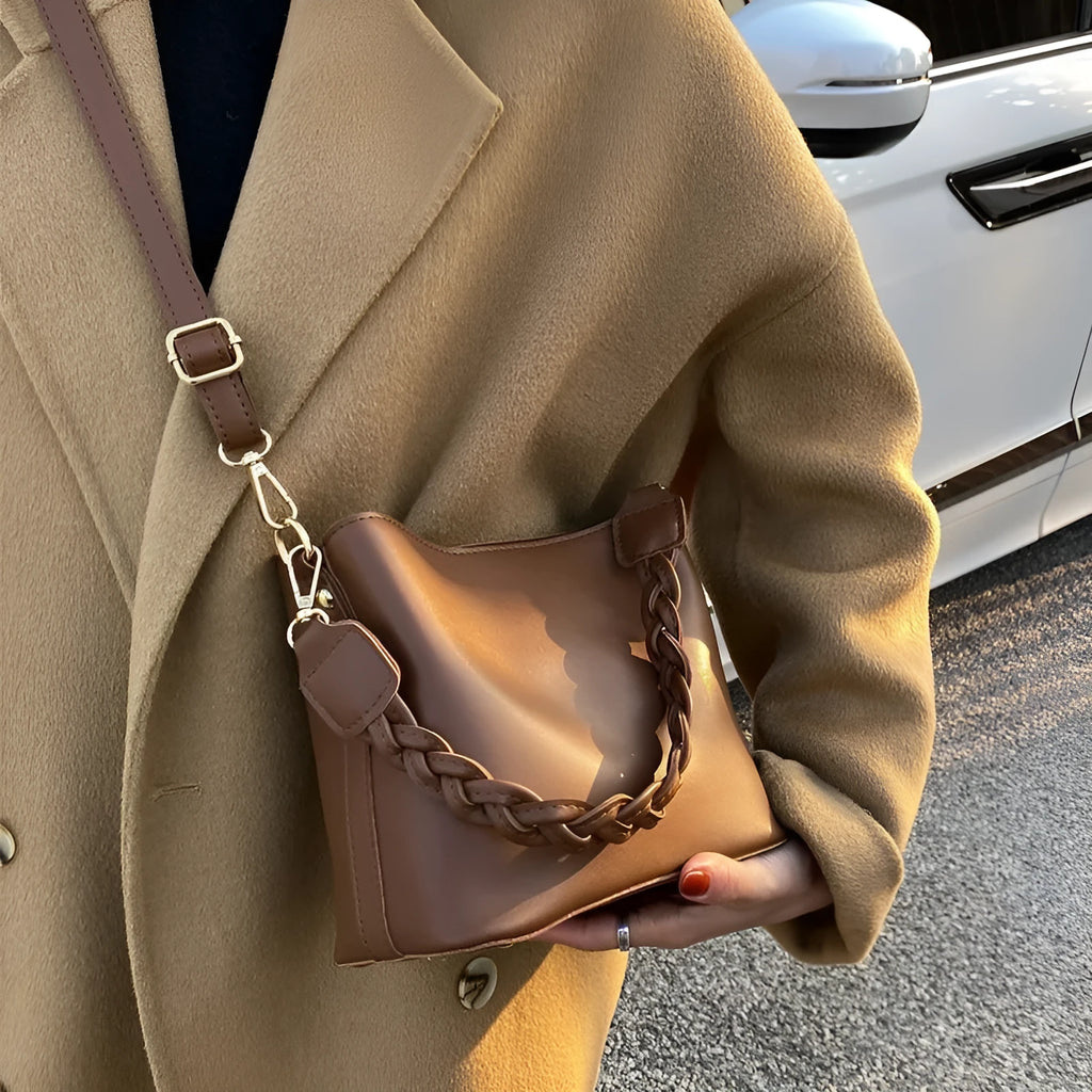 Woven pattern PU leather crossbody bucket bag worn underarm, shown in khaki colour.