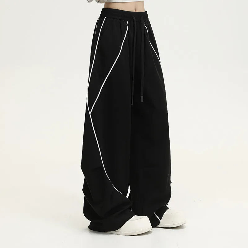 Black striped pleated hip-hop wide-leg sports pants on a hanger.
