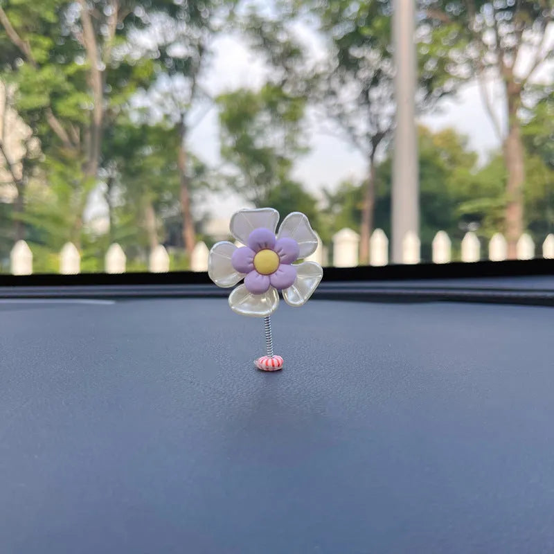 Small blue plastic swing ornament for car dashboard, 5cm tall on a grey surface.