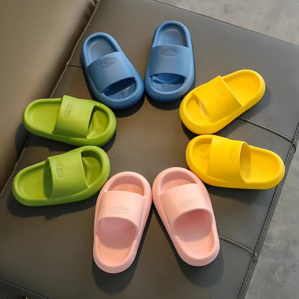 Bright coloured children's EVA slippers with textured sole, shown in blue, green, orange, pink, and yellow.