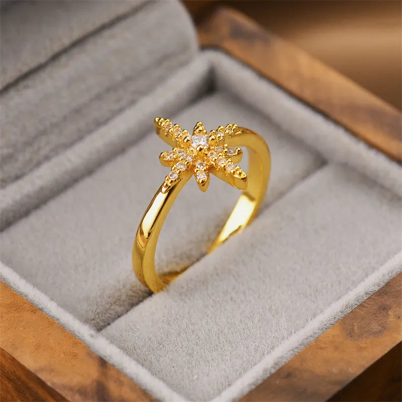 Gold open geometric women's fashion ring on a plain background.