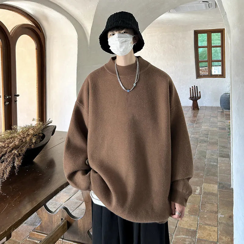 Man wearing a loose grey round neck long sleeve polyester sweater for casual spring or autumn attire.
