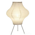 Japanese style table lamp with a white paper shade and a wooden base on a table.