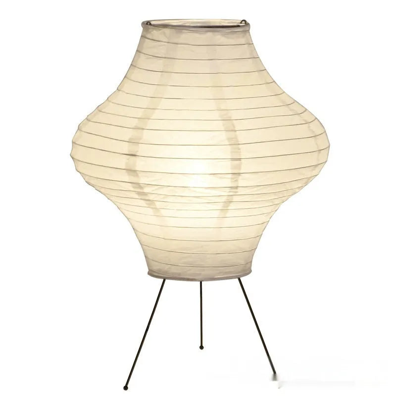 Japanese style table lamp with a white paper shade and a wooden base on a table.