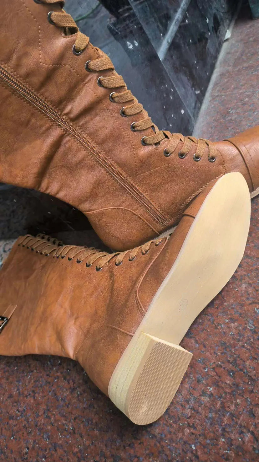 Women's black fashion boots with a cross strap design and side zip closure.
