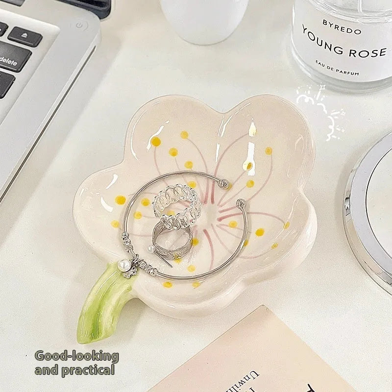 White and pink porcelain shell-shaped tray with integrated yellow LED night light on a wooden table.