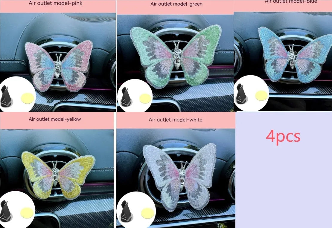 Soft fabric embroidered butterfly car air vent decoration in multiple colour options on a centre console.