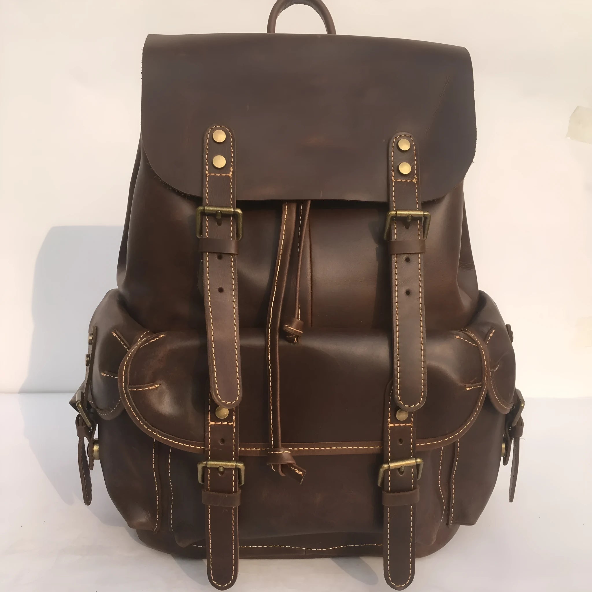 Brown leather men's backpack with shoulder straps showing cowhide leather texture