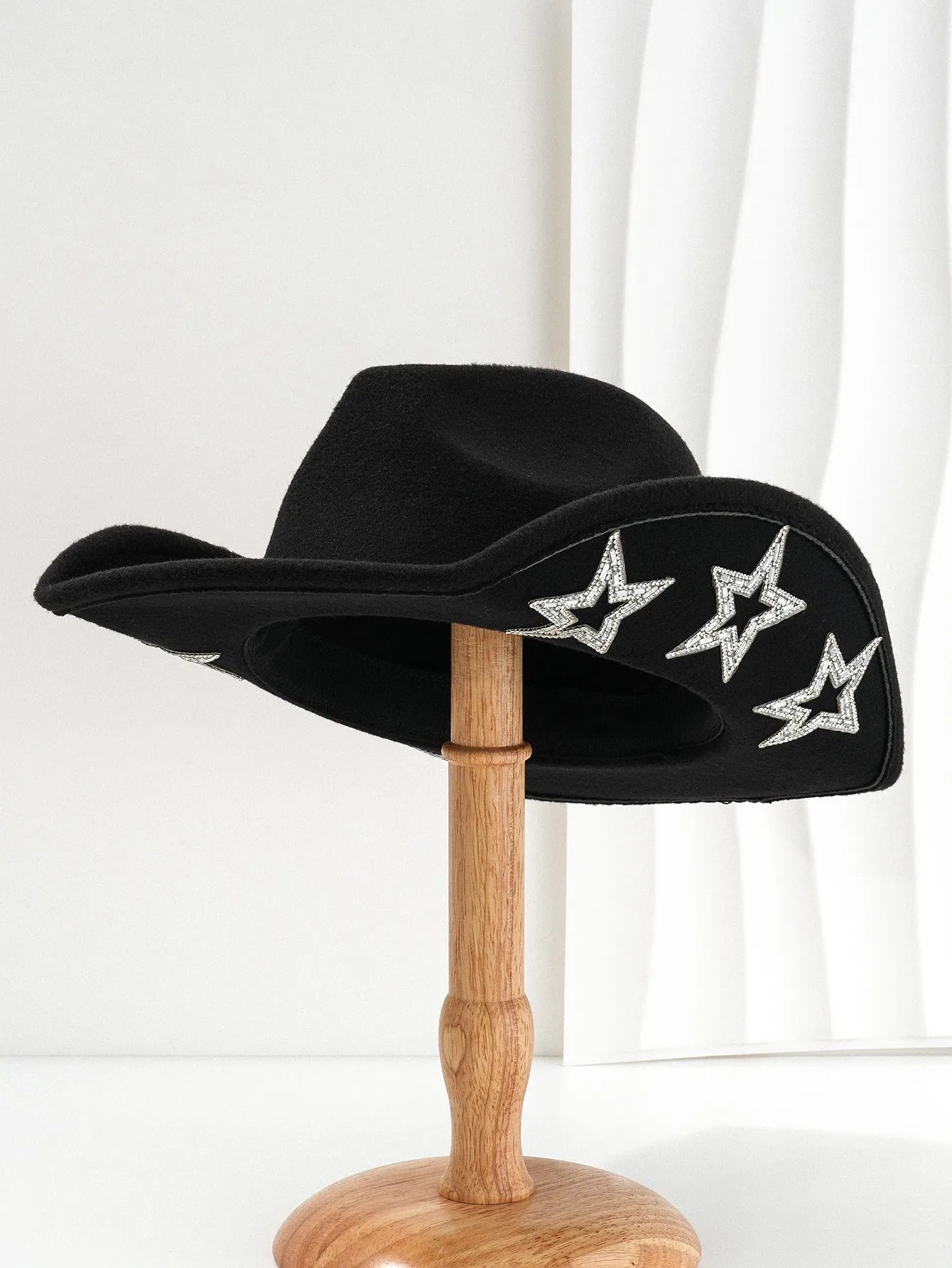 Beige woolen felt Western top hat with a conical crown and a decorative hexagonal star on the front.