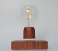 Magnetic levitation floating light bulb hovering above an imitation wood base.