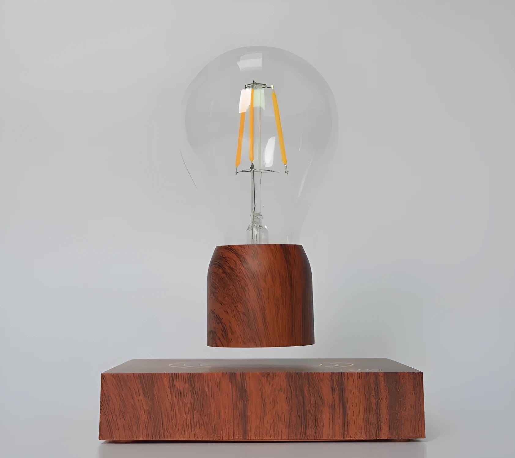 Magnetic levitation floating light bulb hovering above an imitation wood base.