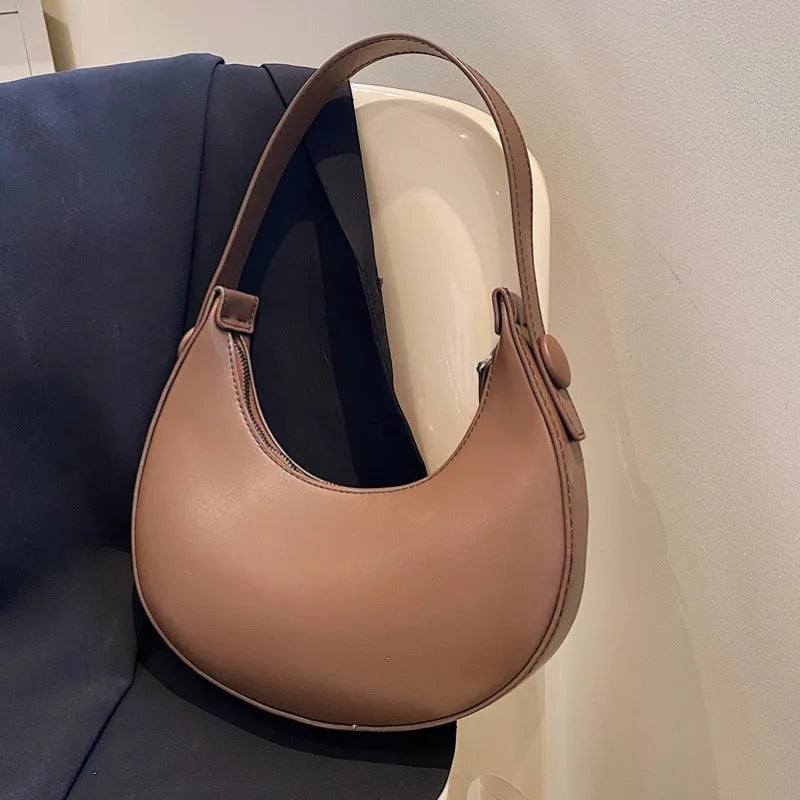 Women's retro-style PU leather shoulder bag in a dumpling shape, shown in black.