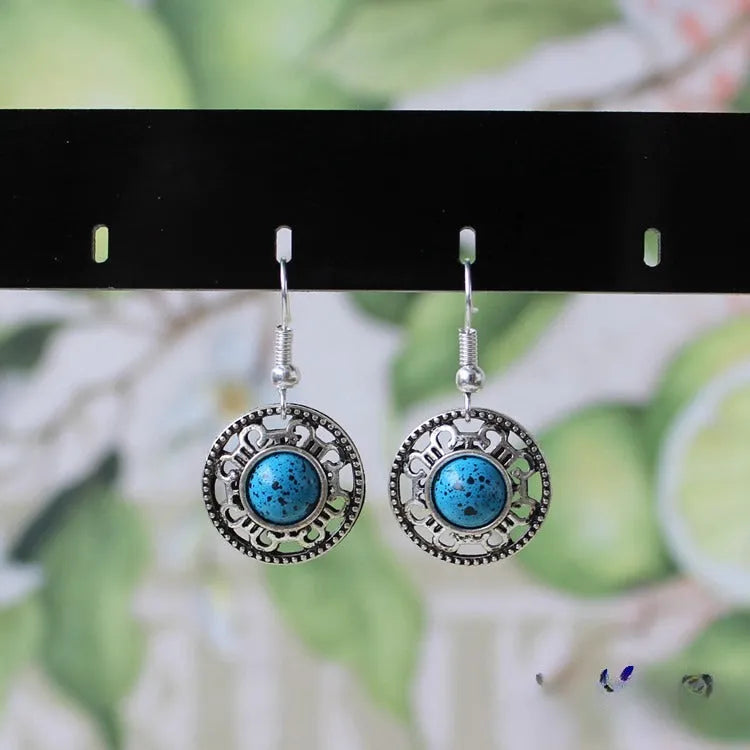 Handmade Miao ethnic silver earrings with turquoise stones in geometric flower disk design