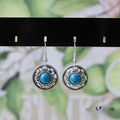 Handmade Miao ethnic silver earrings with turquoise stones in geometric flower disk design