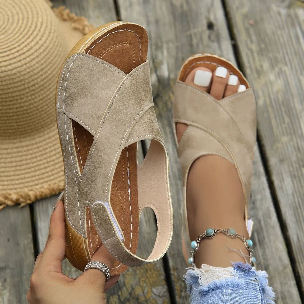 Women's brown roman platform sandals with a skirt detail and Velcro strap closure on a white background.