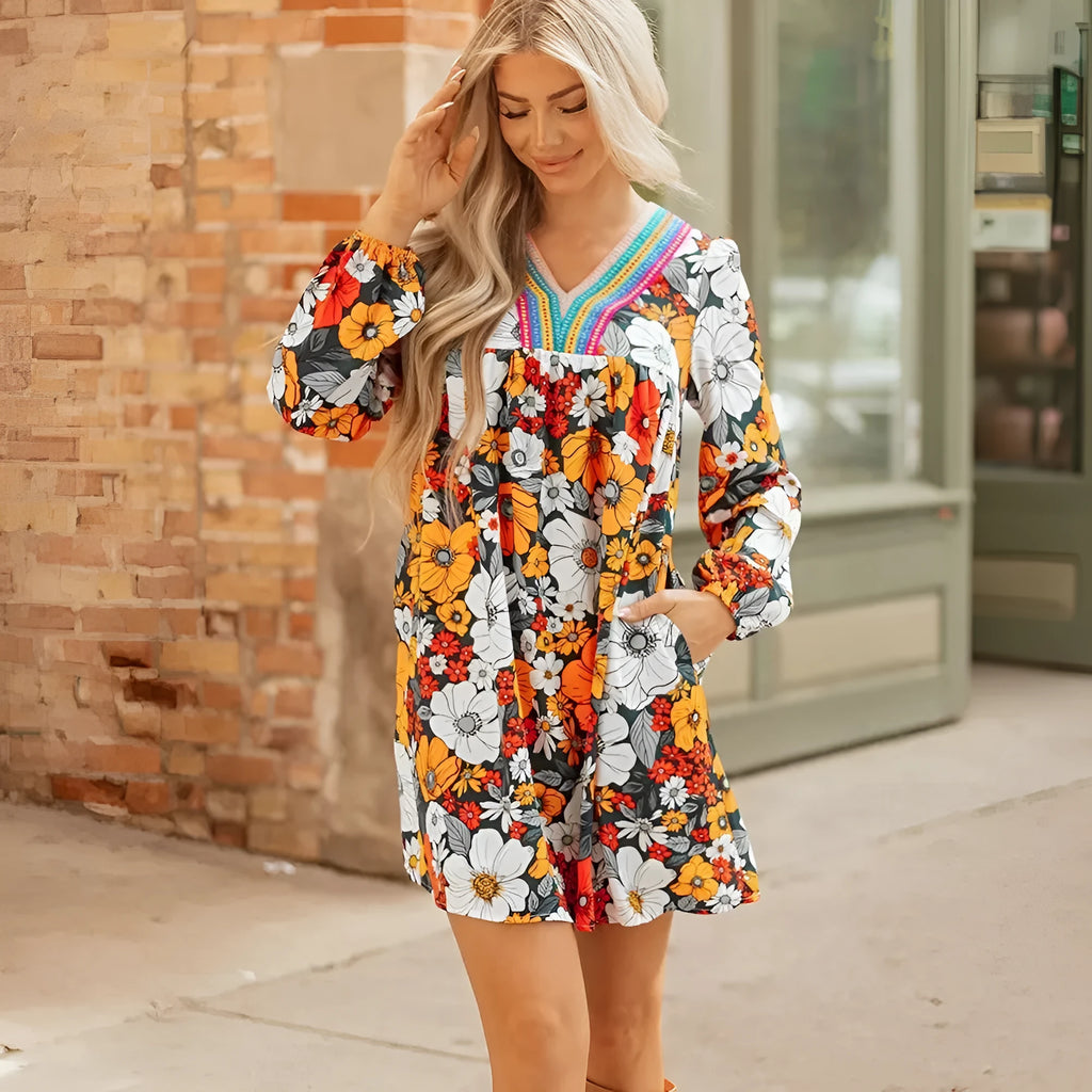 Orange floral print mini dress with lace trim, V-neck, and long sleeves on a hanger.