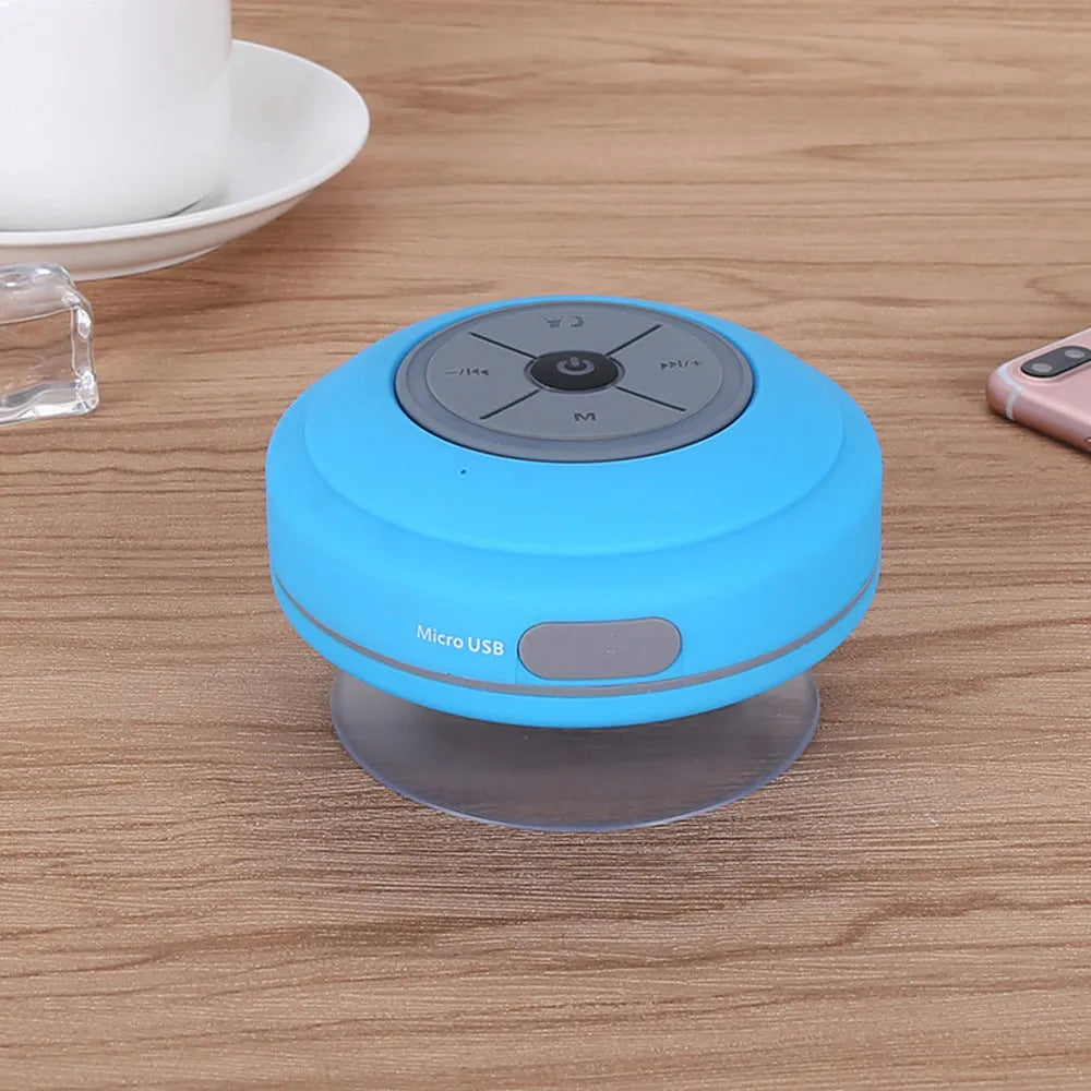 Waterproof suction cup Bluetooth speaker in black attached to a tiled wall