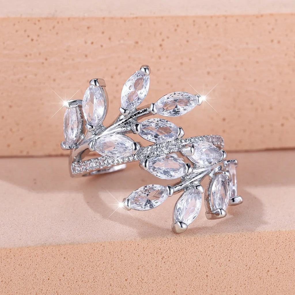 Adjustable copper leaf fashion ring with a central zircon stone on a model's hand, showing rose gold and platinum colour variants.