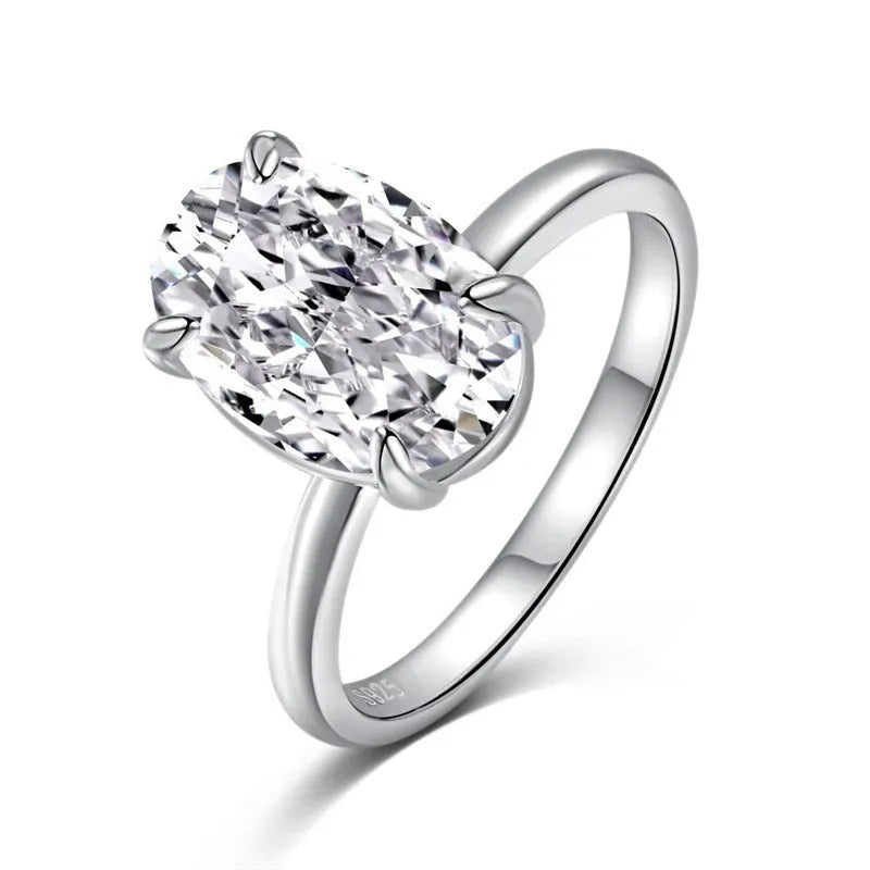 Oval gemstone ring in silver with four-claw setting on a model's hand.
