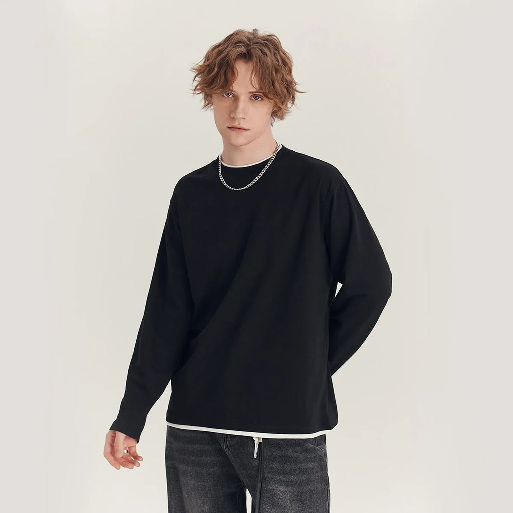 Man wearing a loose fit long-sleeved round neck t-shirt in a solid colour