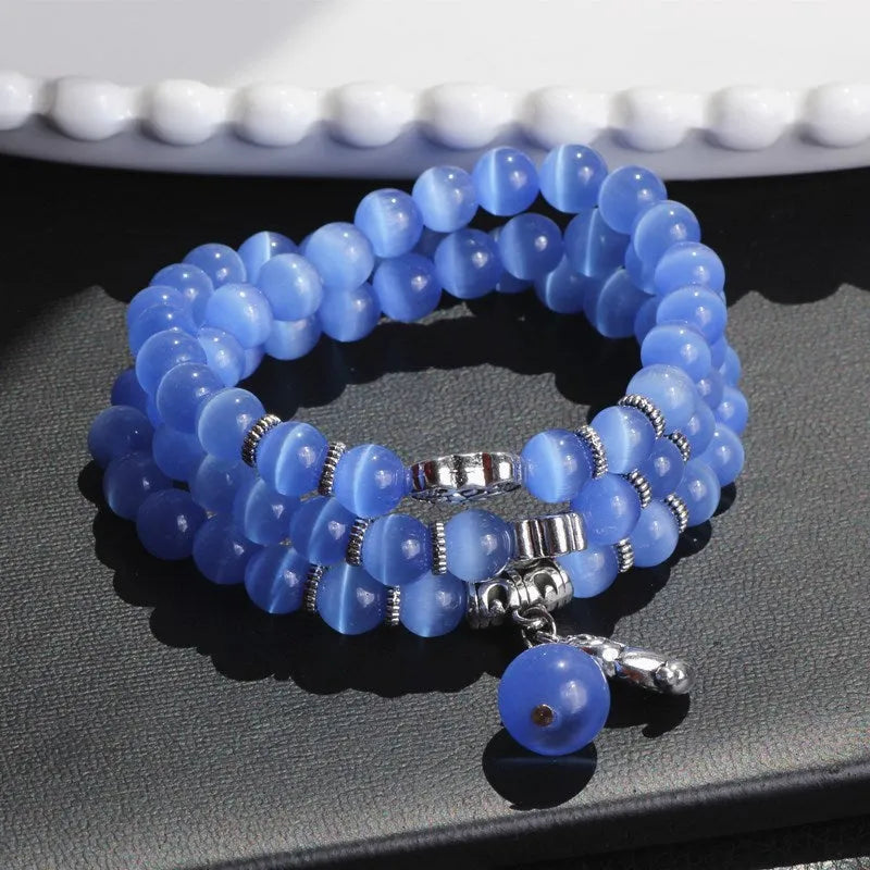 Opal cat eye bracelet with three geometric rings and lucky cat charms on adjustable 52cm cord