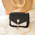 Small square PU leather messenger bag with cat tassel decoration and chain strap on a white background