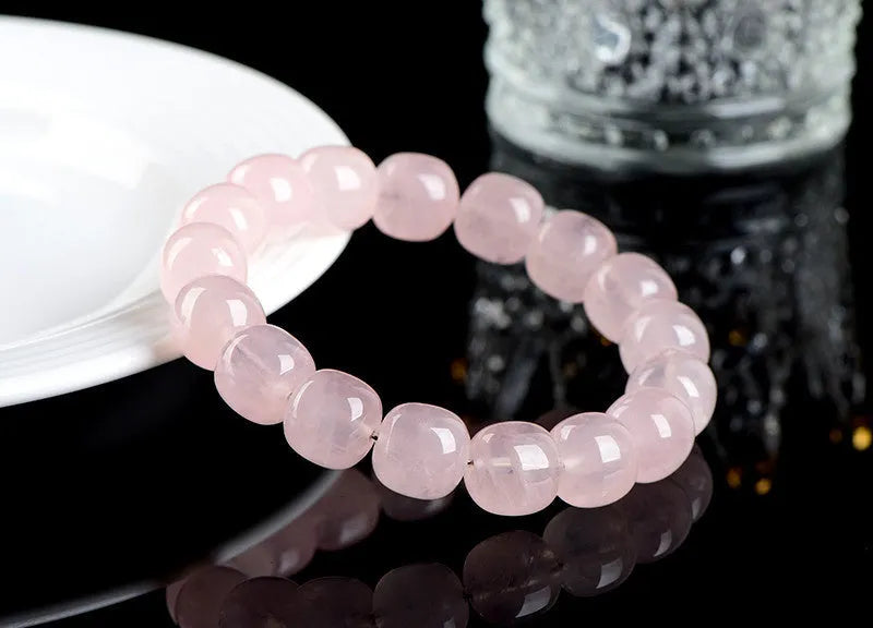 Pink crystal barrel bead bracelet on a black adjustable cord, showing geometric design.