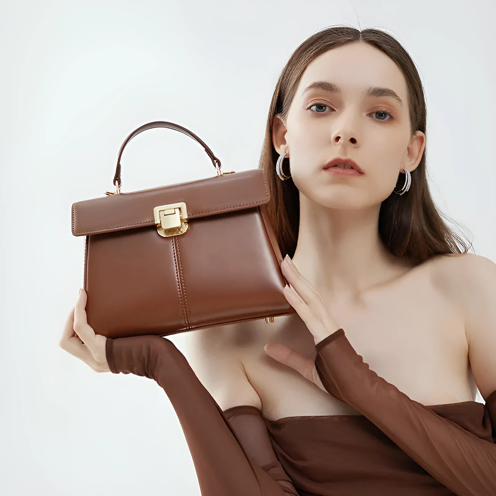 Black genuine leather women's clasp shoulder bag with square shape and long strap.
