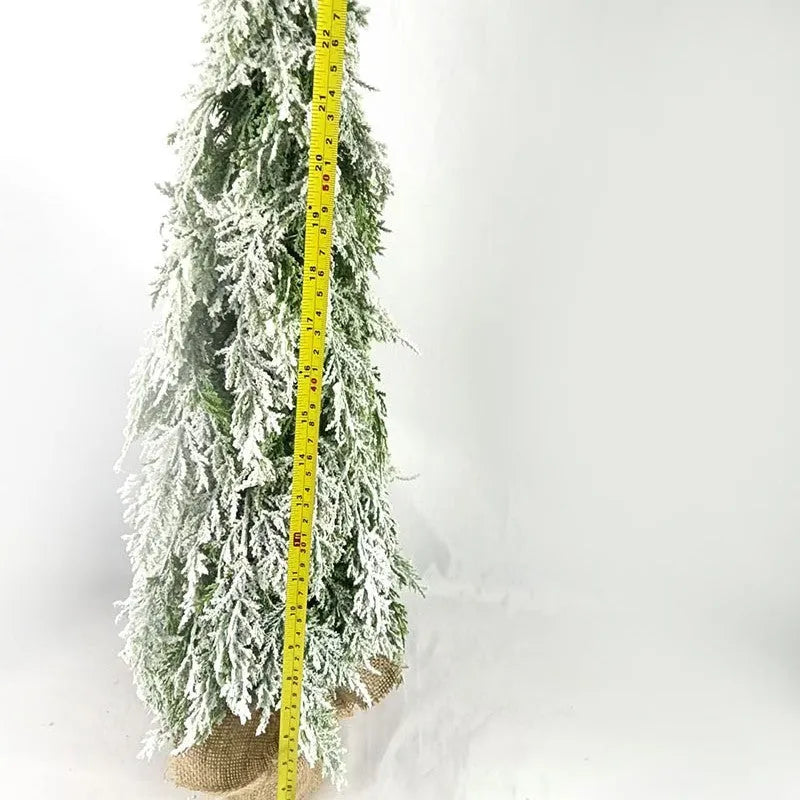 Small 24-inch white artificial Christmas tree with lights and snow spray on a desktop