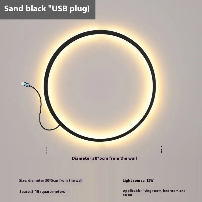 Minimalist black ring wall lamp with acrylic shade mounted on a bedroom wall