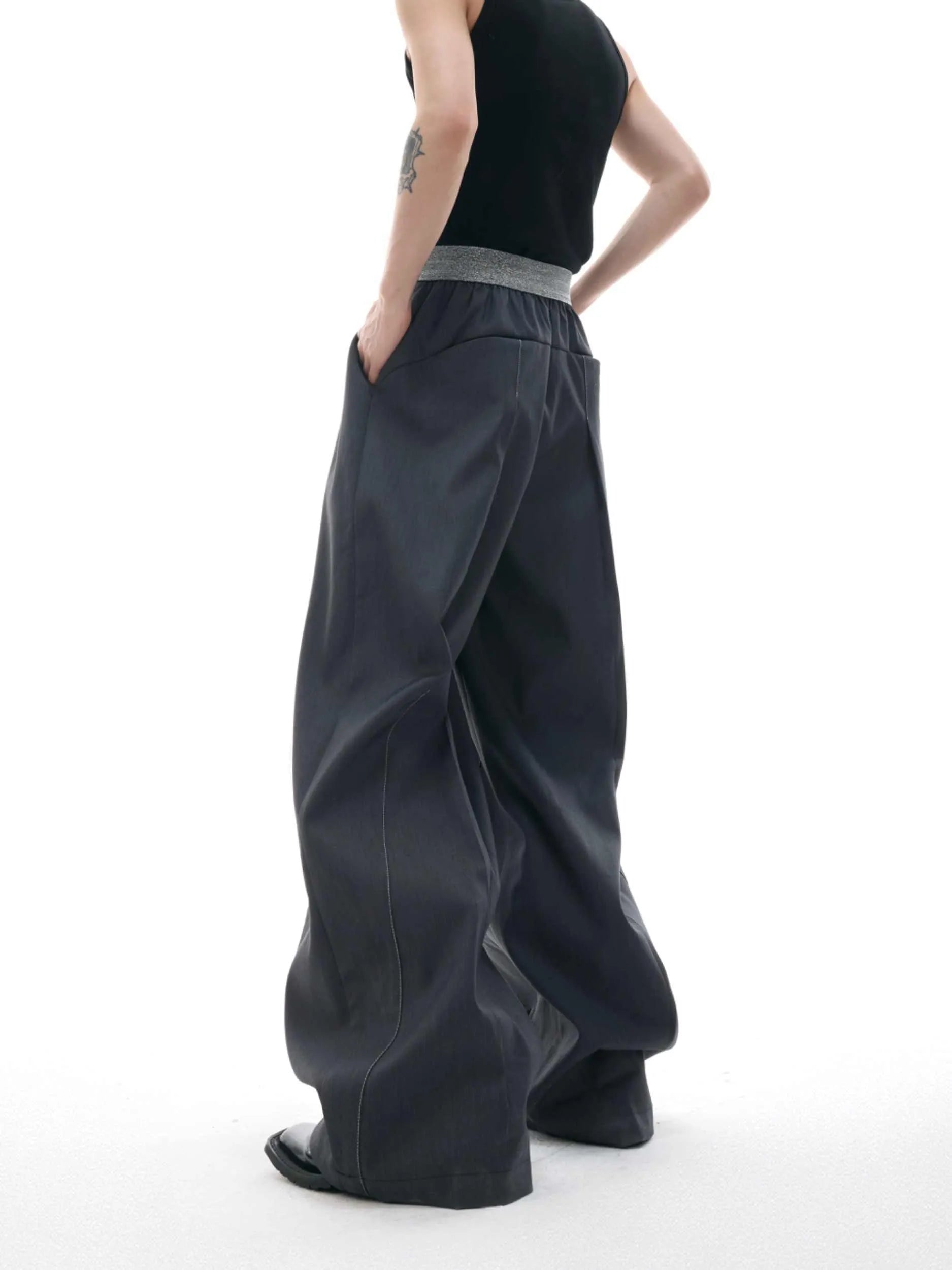 Straight-leg high-waisted trousers in grey fabric with button detail on the leg.