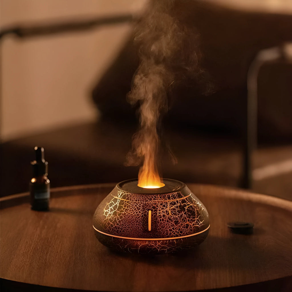 White round desktop aroma diffuser humidifier with colourful LED flame effect light on.