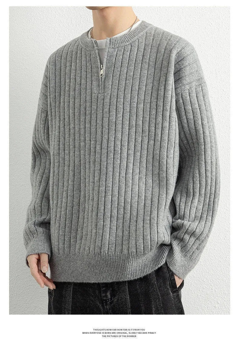 A grey men's textured knit half-zip sweater with a loose fit and long sleeves on a mannequin.