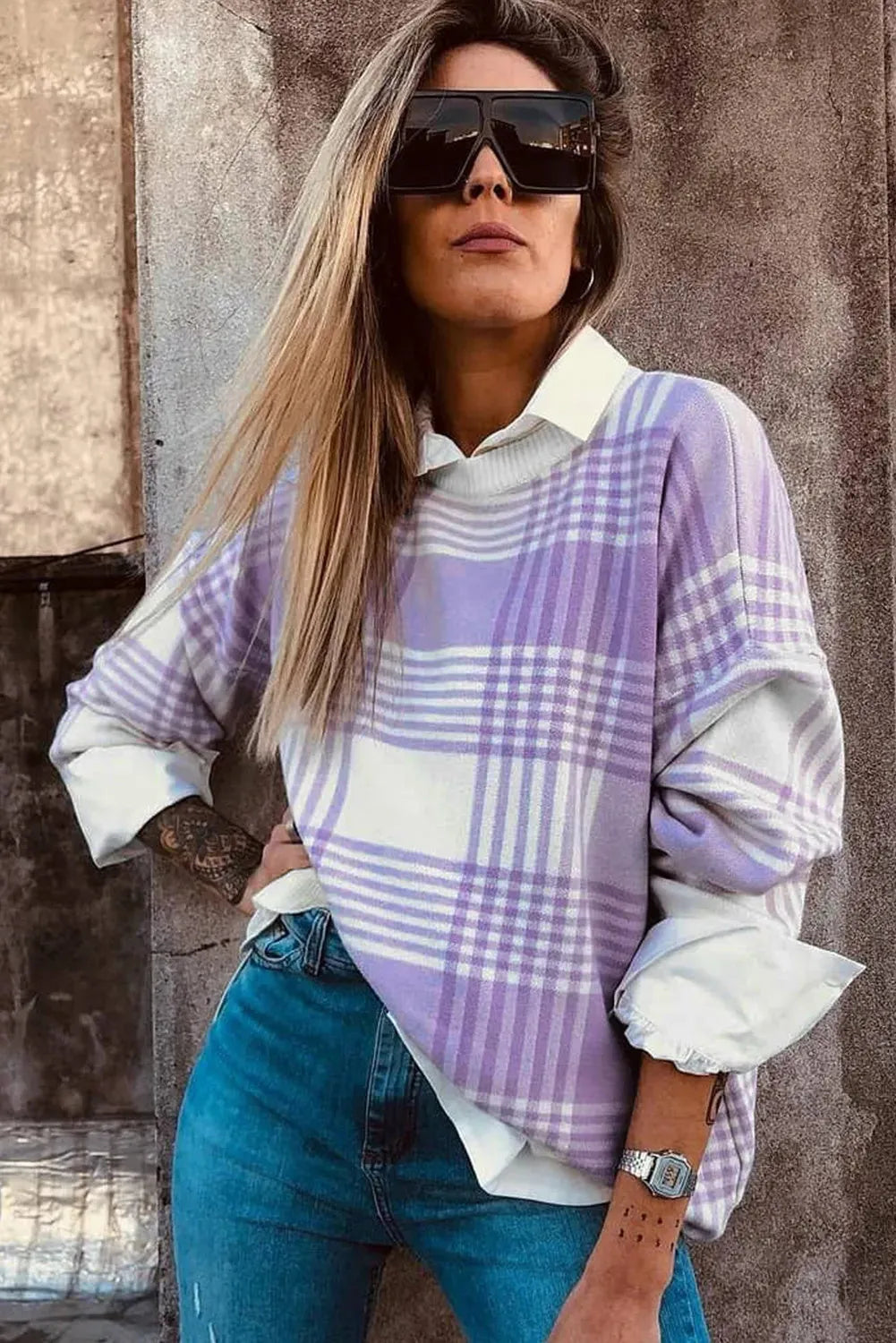 Lilac plaid print loose women's sweater with ribbed collar and cuffs on a hanger.