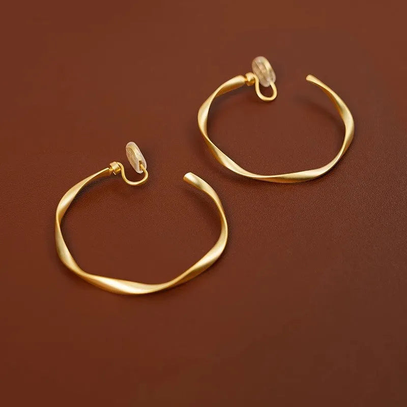 Rotatable circle mosquito coil ear clip in matte gold with rubber pads for women
