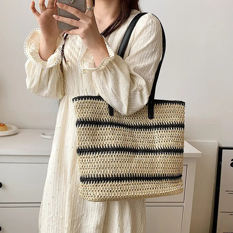 Large striped straw woven handbag with 64cm shoulder strap and polyester lining, shown in khaki or black