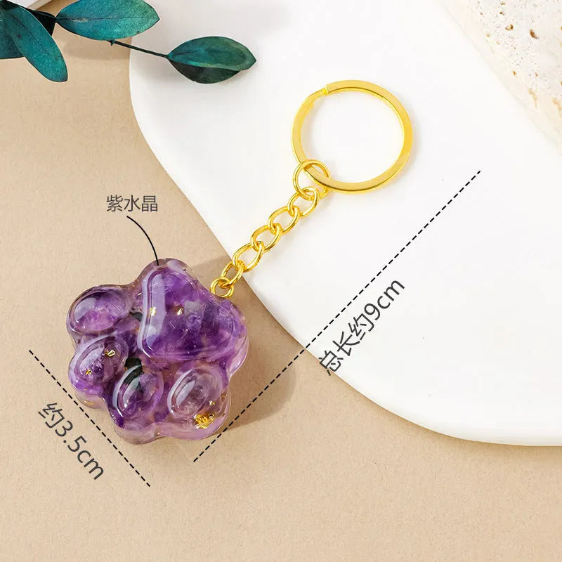 Natural crystal cat's paw shape pendant on a metal keyring, showing example of polished stone like turquoise or amethyst.