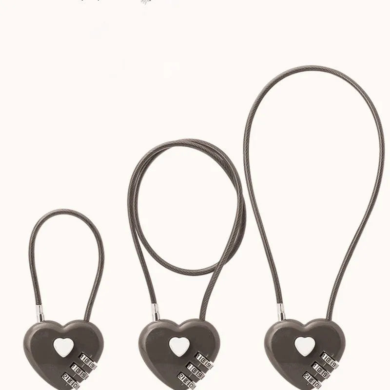 Peach heart shaped combination lock with a long black steel cable, shown in blue plastic.