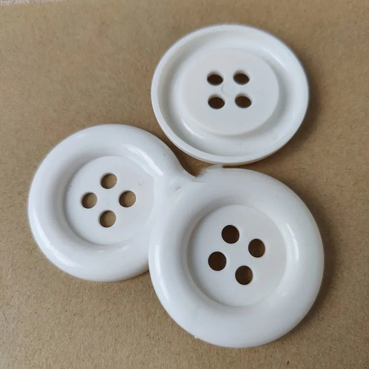 Oversized plastic round edge button with four holes in assorted colours and sizes