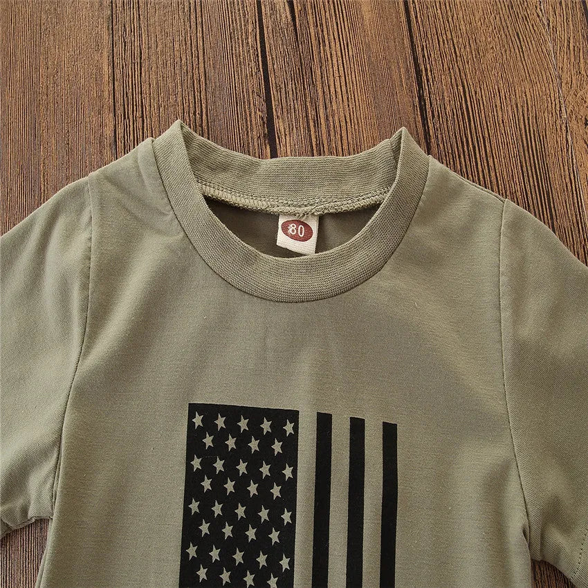 Little boy wearing a US flag camouflage print short-sleeved shirt and matching trousers.