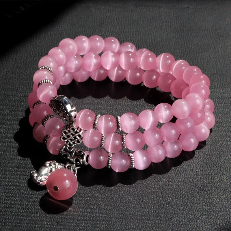 Opal cat eye bracelet with three geometric rings and lucky cat charms on adjustable 52cm cord