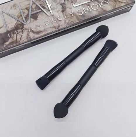 Elegant black double-headed makeup brush with a synthetic fibre brush and a miter sponge on a wooden handle.