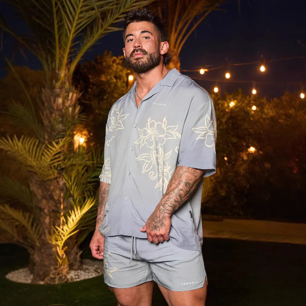 Man wearing a loose, short-sleeved printed floral top in a light colour.